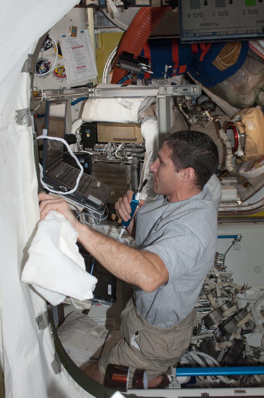 ISS037-E-020099 (24 Oct. 2013) --- NASA astronaut Michael Hopkins, Expedition 37 flight engineer, speaks in a microphone while working in the Quest airlock of the International Space Station.