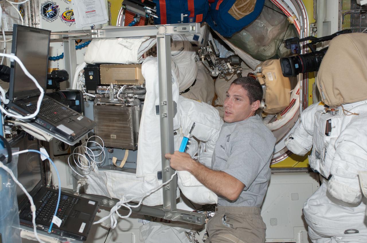 ISS037-E-020101 (24 Oct. 2013) --- NASA astronaut Michael Hopkins, Expedition 37 flight engineer, works with an Extravehicular Mobility Unit (EMU) spacesuit in the Quest airlock of the International Space Station.