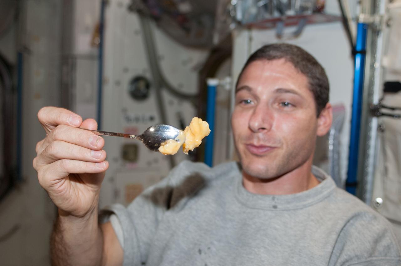 ISS037-E-021314 (26 Oct. 2013) --- NASA astronaut Michael Hopkins, Expedition 37 flight engineer, holds a spoon containing a piece of food in the Harmony node of the International Space Station.