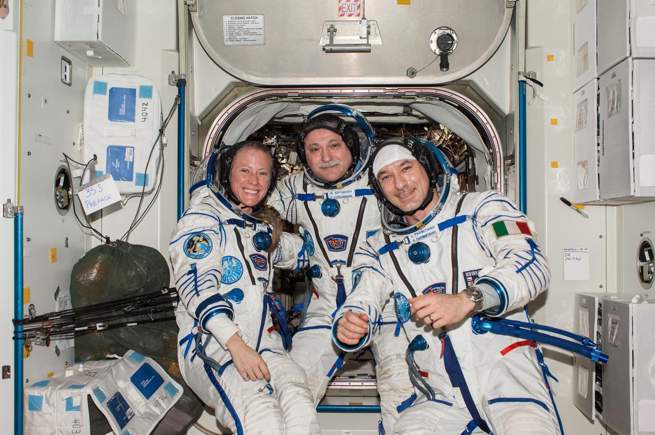 ISS037-E-021360 (27 Oct. 2013) --- Attired in Russian Sokol launch and entry suits, Russian cosmonaut Fyodor Yurchikhin (center), Expedition 37 commander; along with NASA astronaut Karen Nyberg and European Space Agency astronaut Luca Parmitano, both flight engineers, pose for a portrait in the Unity node of the International Space Station.