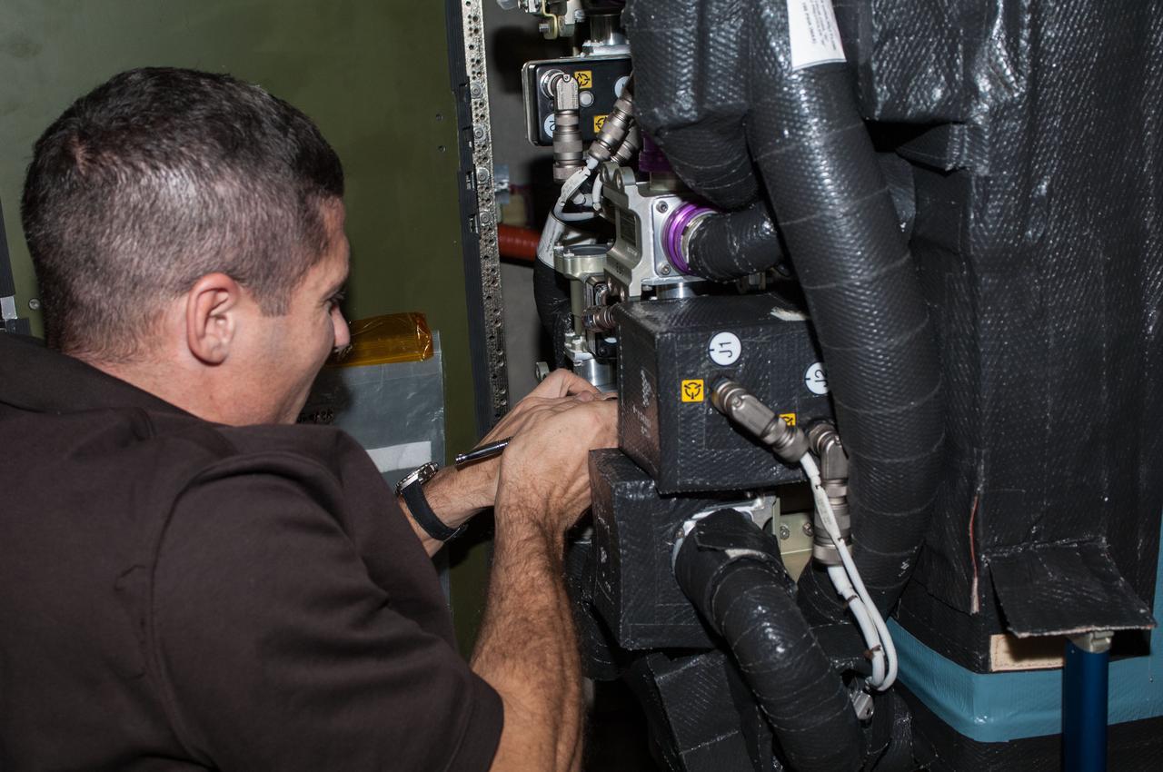 ISS037-E-021962 (28 Oct. 2013) --- NASA astronaut Michael Hopkins, Expedition 37 flight engineer, performs routine in-flight maintenance within the Carbon Dioxide Removal Assembly in the International Space Station?s Tranquility node. This device removes carbon dioxide from the station?s atmosphere and is part of the station?s Environmental Control and Life Support System that provides clean water and air to the crew.