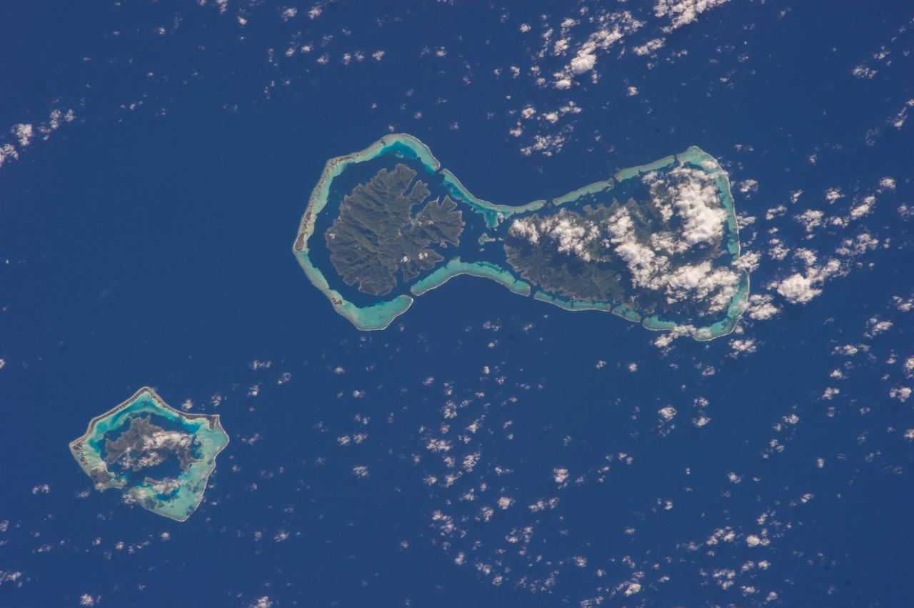 ISS037-E-022125 (28 Oct. 2013) --- The interesting color contrasts of the water surrounding the atolls of Pinaki (bottom) and Nukutavake in French Polynesia caught the eye of one of the Expedition 37 crew members aboard the Earth-orbiting International Space Station on Oct. 28. At first glance to a pair of sleepy eyes, the atolls might look somewhat like a bottle cap and a bottle opener.