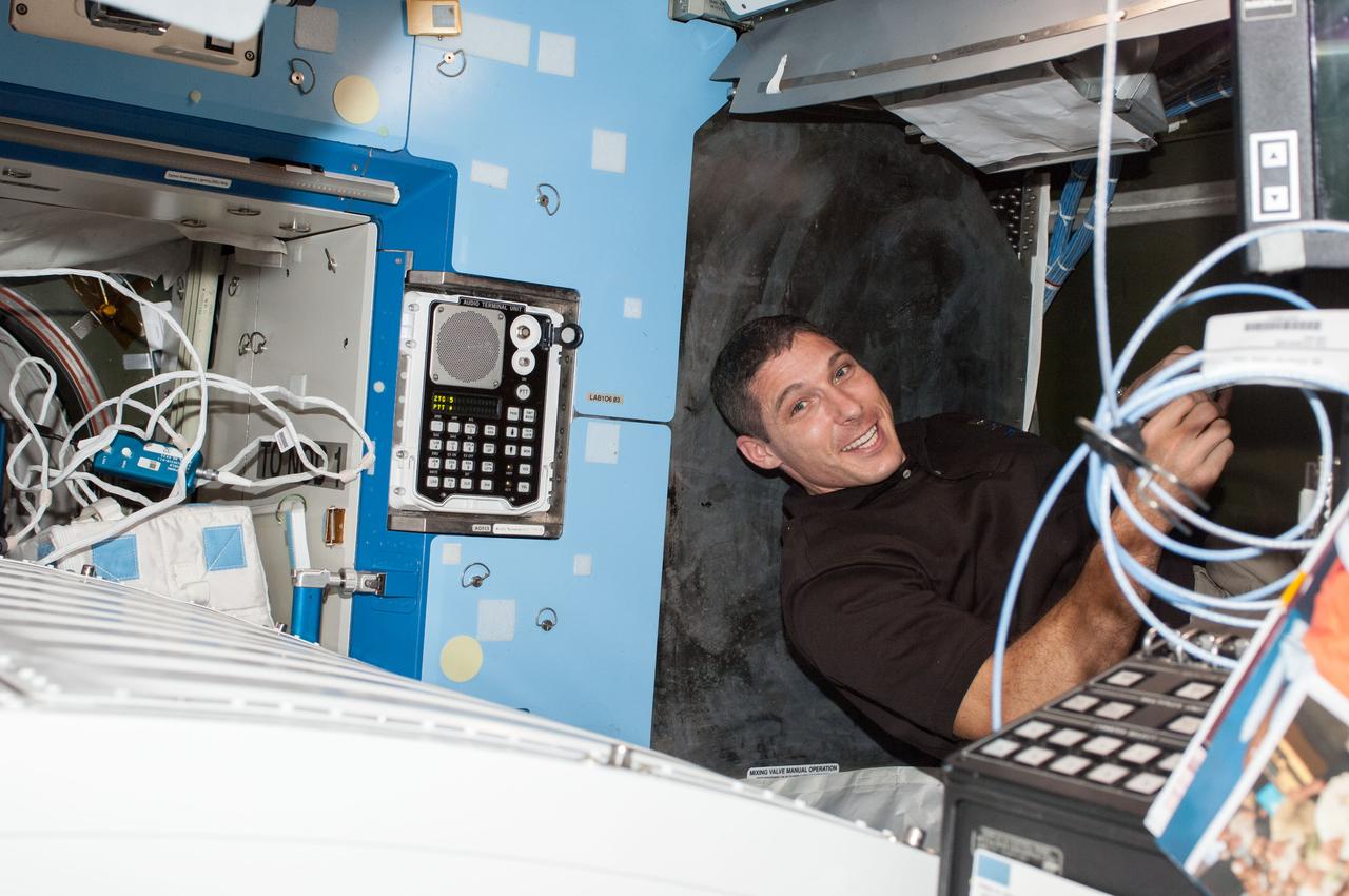 ISS037-E-024833 (28 Oct. 2013) --- NASA astronaut Michael Hopkins, Expedition 37 flight engineer, works behind a rack in the Destiny laboratory of the International Space Station.