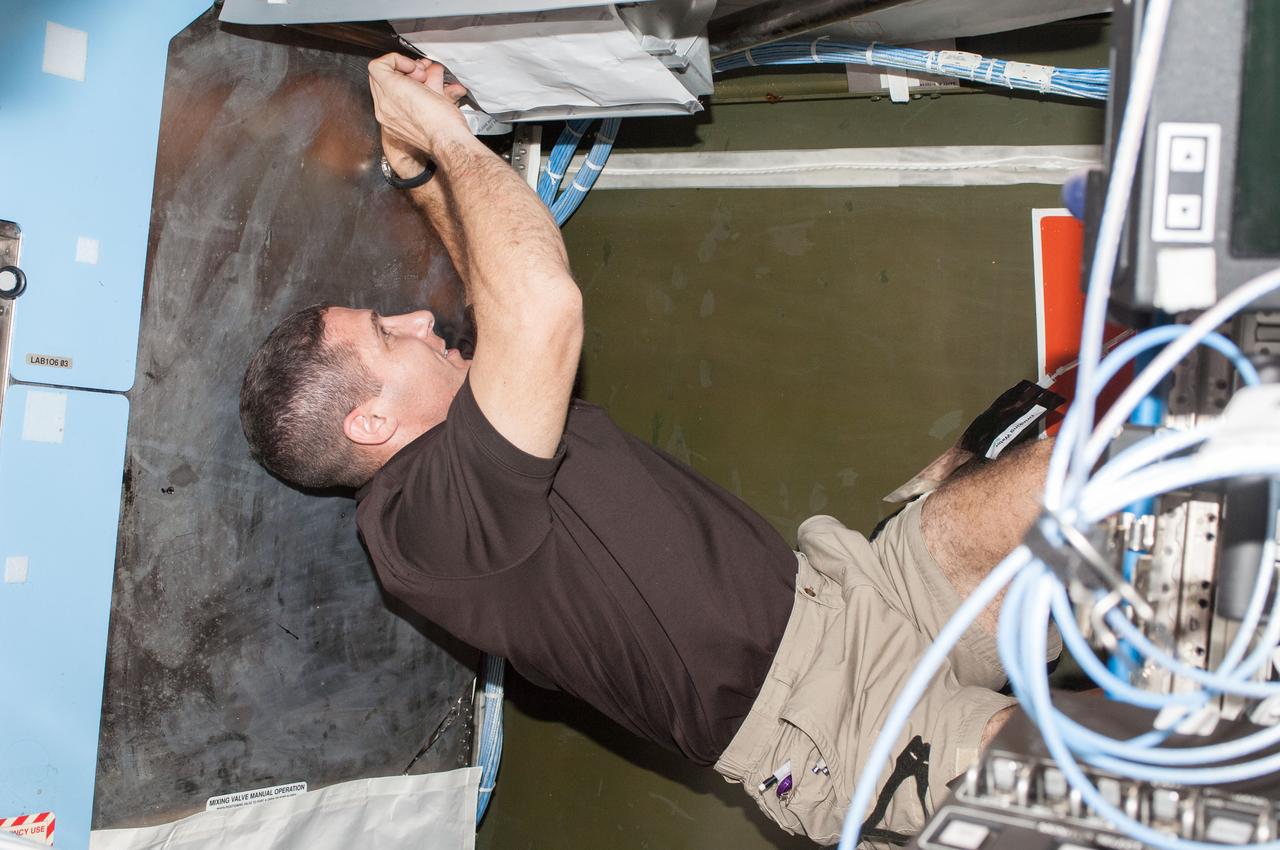 ISS037-E-024834 (28 Oct. 2013) --- NASA astronaut Michael Hopkins, Expedition 37 flight engineer, works behind a rack in the Destiny laboratory of the International Space Station.