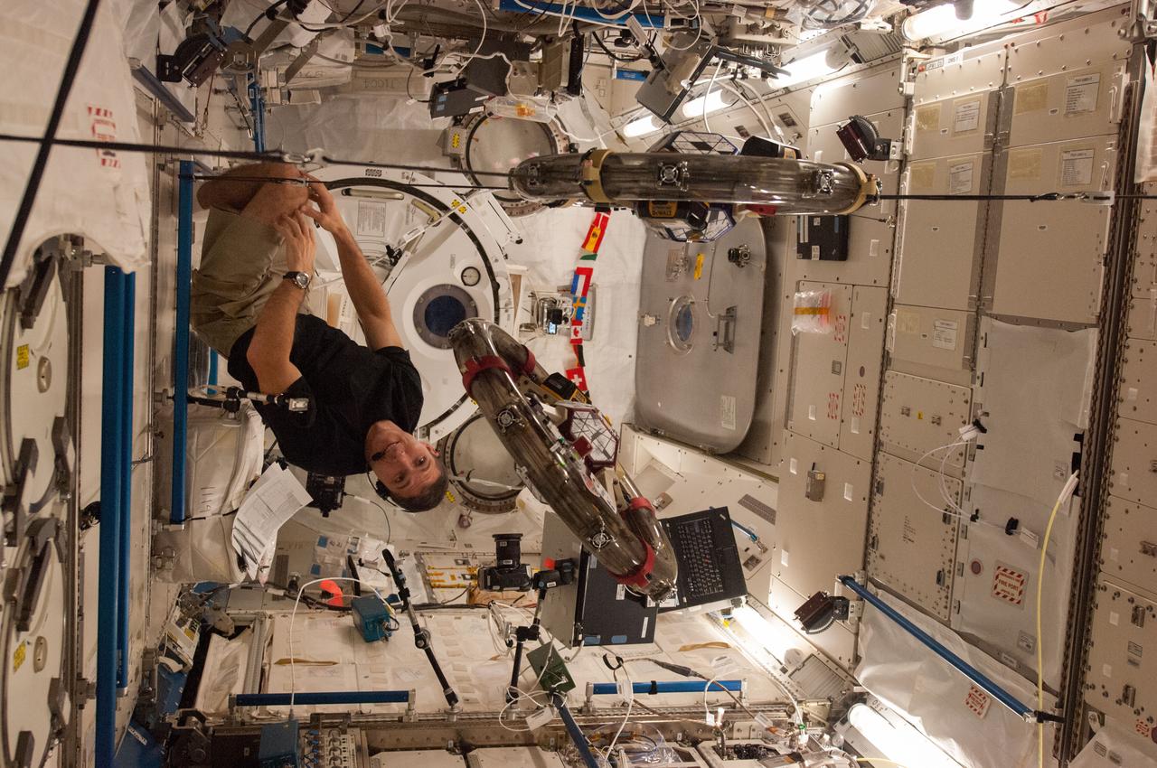 ISS037-E-025870 (4 Nov. 2013) --- In the International Space Station?s Kibo laboratory, NASA astronaut Michael Hopkins, Expedition 37 flight engineer, conducts a session with a pair of bowling-ball-sized free-flying satellites known as Synchronized Position Hold, Engage, Reorient, Experimental Satellites, or SPHERES. Surrounding the two SPHERES mini-satellites is ring-shaped hardware known as the Resonant Inductive Near-field Generation System, or RINGS. SPHERES-RINGS seeks to demonstrate wireless power transfer between satellites at a distance for enhanced operations.