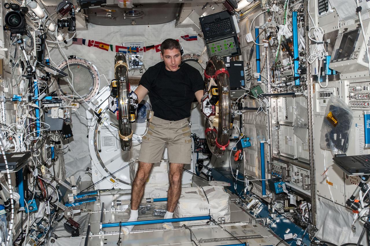 ISS037-E-025915 (4 Nov. 2013) --- In the International Space Station?s Kibo laboratory, NASA astronaut Michael Hopkins, Expedition 37 flight engineer, conducts a session with a pair of bowling-ball-sized free-flying satellites known as Synchronized Position Hold, Engage, Reorient, Experimental Satellites, or SPHERES. Surrounding the two SPHERES mini-satellites is ring-shaped hardware known as the Resonant Inductive Near-field Generation System, or RINGS. SPHERES-RINGS seeks to demonstrate wireless power transfer between satellites at a distance for enhanced operations.