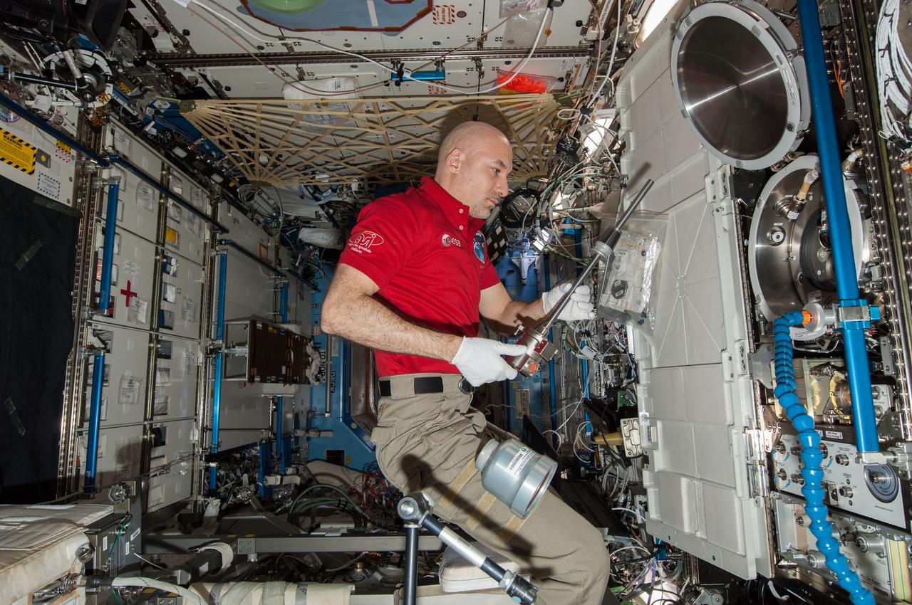 ISS037-E-026919 (4 Nov. 2013) --- European Space Agency astronaut Luca Parmitano, Expedition 37 flight engineer, works with the Combustion Integrated Rack (CIR) Multi-user Drop Combustion Apparatus (MDCA) in the Destiny laboratory of the International Space Station.