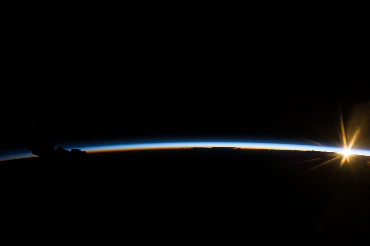 Earth observation taken during day pass by an Expedition 37 crew member on board the International Space Station (ISS).   Part of Space Station Remote Manipulator System (SSRMS) arm visible. Identified via Twitter message as sunrise.