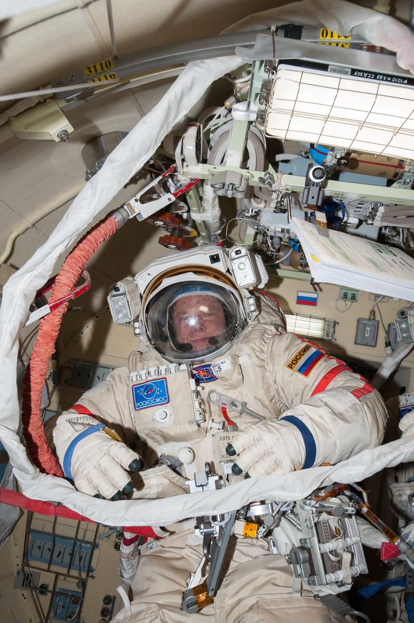 ISS037-E-029029 (5 Nov. 2013) --- In the International Space Station?s Pirs docking compartment, Russian cosmonaut Oleg Kotov, Expedition 37 flight engineer, wearing his Russian Orlan spacesuit, prepares for a session of extravehicular activity (EVA) scheduled for Nov. 9, 2013.