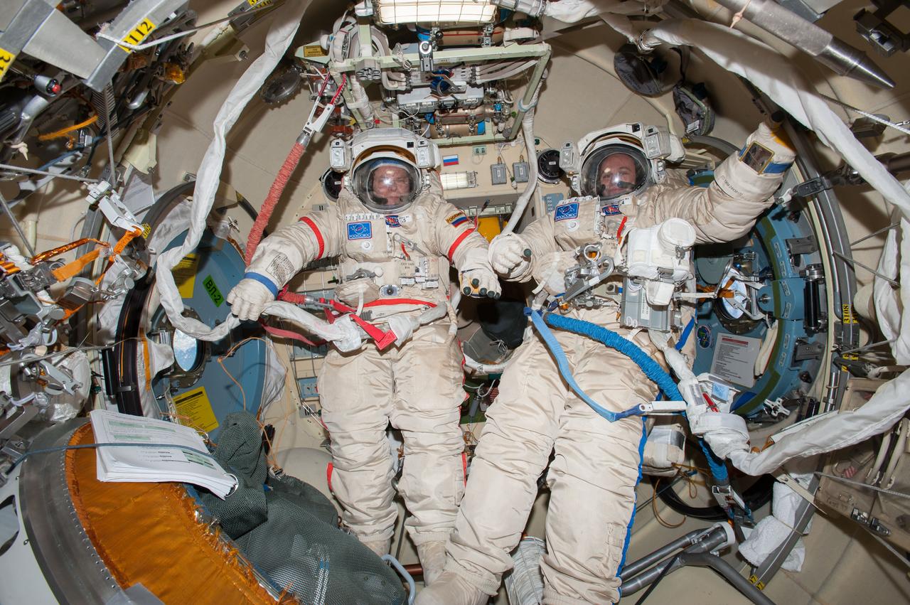 ISS037-E-029081 (5 Nov. 2013) --- In the International Space Station?s Pirs docking compartment, Russian cosmonauts Oleg Kotov (left) and Sergey Ryazanskiy, both Expedition 37 flight engineers, wearing their Russian Orlan spacesuits, prepare for a session of extravehicular activity (EVA) scheduled for Nov. 9, 2013.
