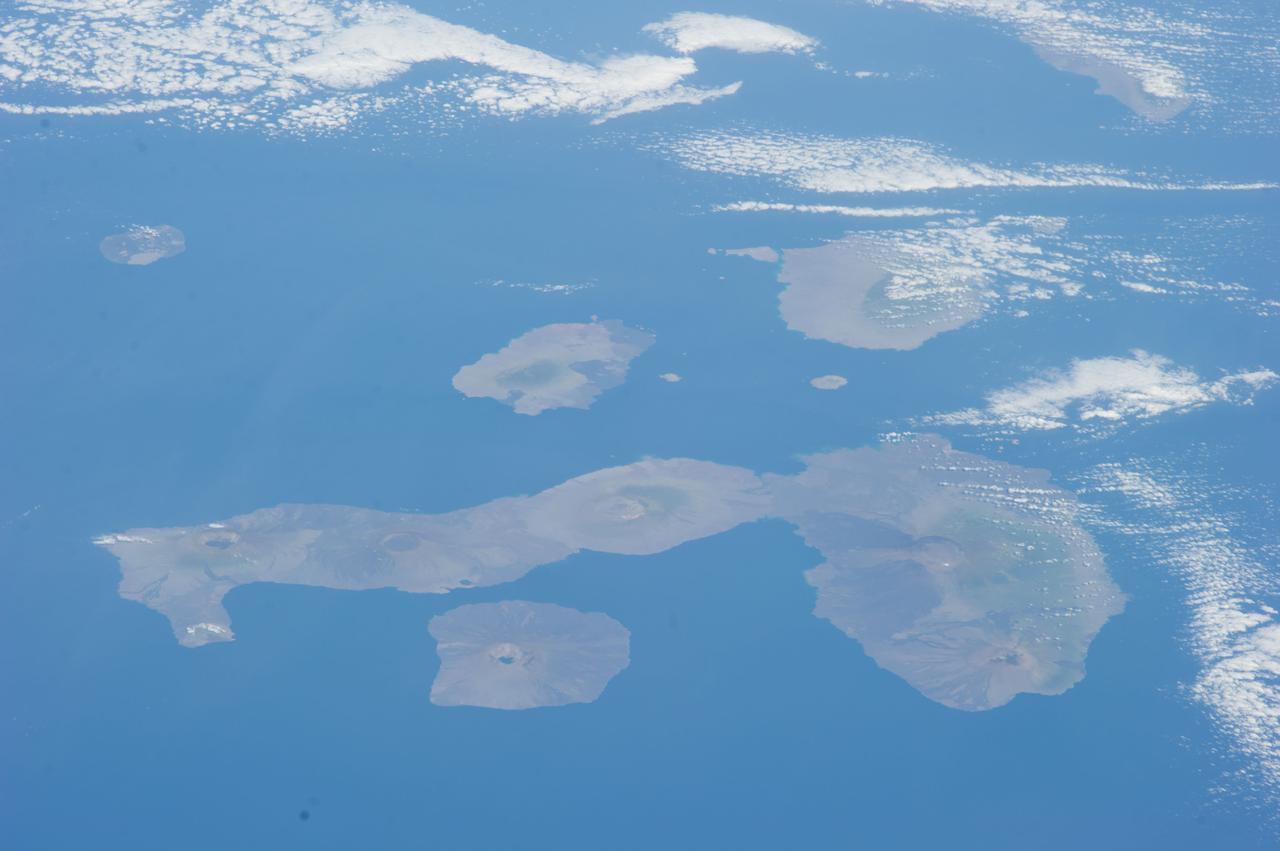 ISS038-E-000232 (11 Nov. 2013) --- One of the Expedition 38 crew members aboard the International Space Station used a 180mm lens to photograph this oblique image featuring the Galapagos Islands or Islas Galapagos, distributed on either side of the Equator in the eastern Pacific Ocean. An archipelago of volcanic islands, the group?s official name is Archipielago de Colon.