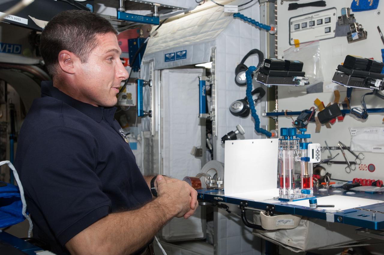 ISS038-E-000263 (11 Nov. 2013) --- NASA astronaut Michael Hopkins, Expedition 38 flight engineer, conducts a session with the Capillary Flow Experiment (CFE) in the Harmony node of the International Space Station. CFE is a suite of fluid physics experiments that investigate how fluids move up surfaces in microgravity. The results aim to improve current computer models that are used by designers of low gravity fluid systems and may improve fluid transfer systems for water on future spacecraft.