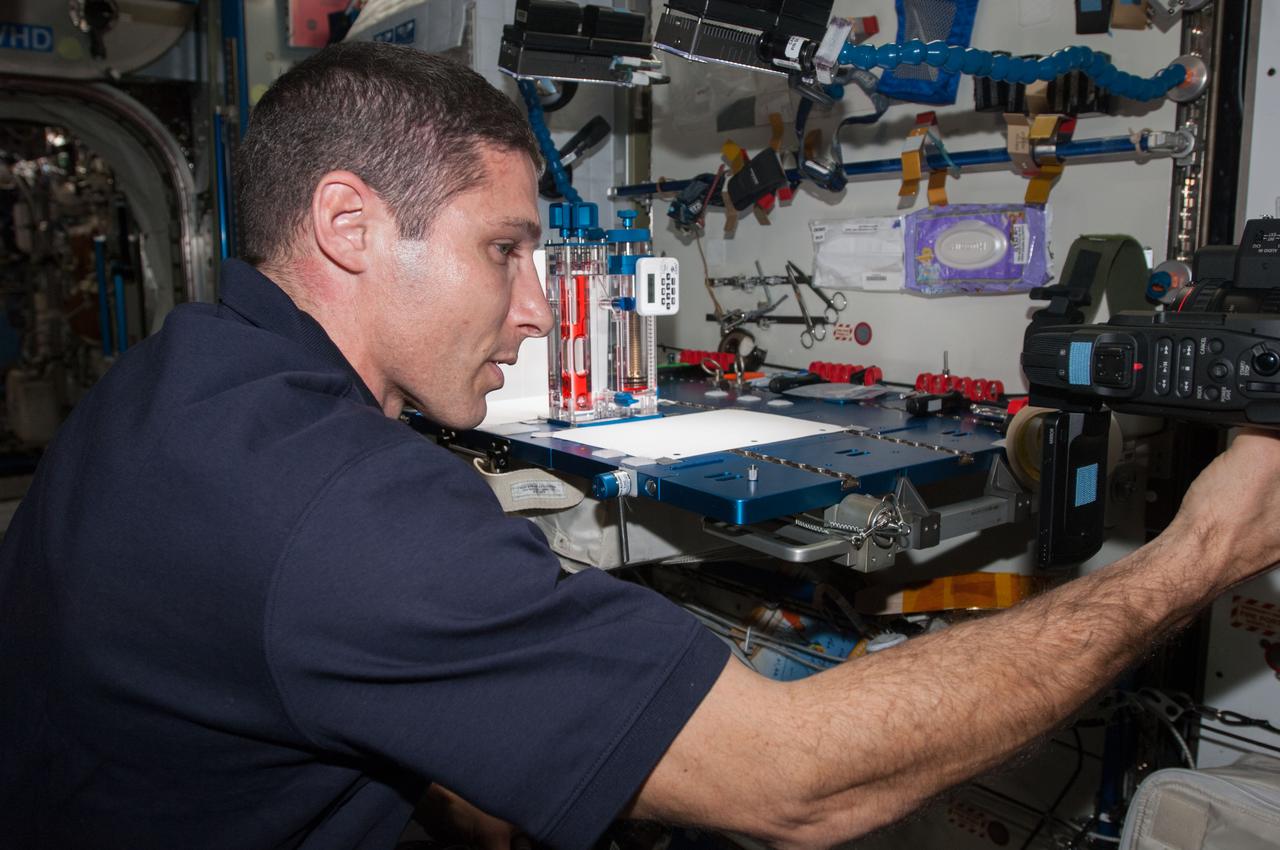 ISS038-E-000269 (11 Nov. 2013) --- NASA astronaut Michael Hopkins, Expedition 38 flight engineer, conducts a session with the Capillary Flow Experiment (CFE) in the Harmony node of the International Space Station. CFE is a suite of fluid physics experiments that investigate how fluids move up surfaces in microgravity. The results aim to improve current computer models that are used by designers of low gravity fluid systems and may improve fluid transfer systems for water on future spacecraft.