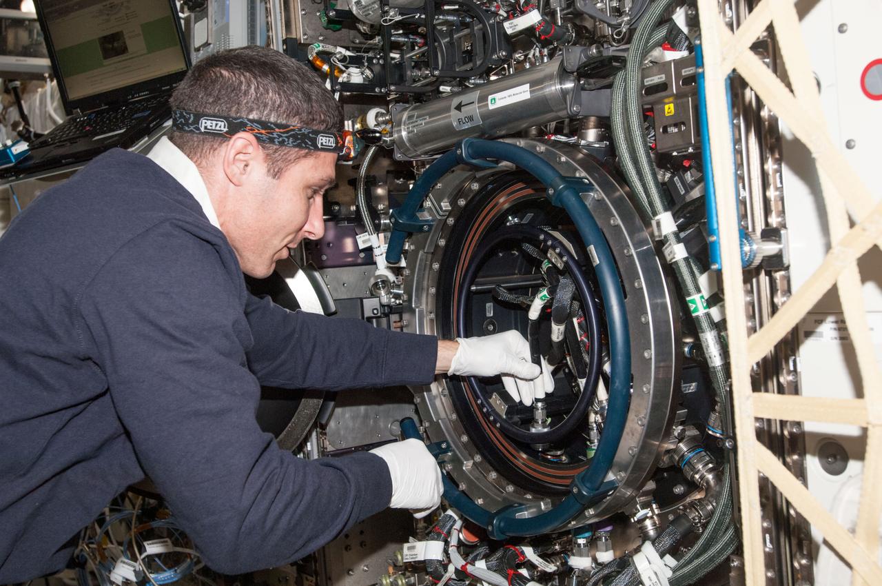 ISS038-E-001298 (12 Nov. 2013) --- NASA astronaut Michael Hopkins, Expedition 38 flight engineer, works with the Multi-user Drop Combustion Apparatus (MDCA) inside the Combustion Integrated Rack (CIR) in the Destiny laboratory of the International Space Station. The MDCA contains hardware and software to conduct unique droplet combustion experiments in space.