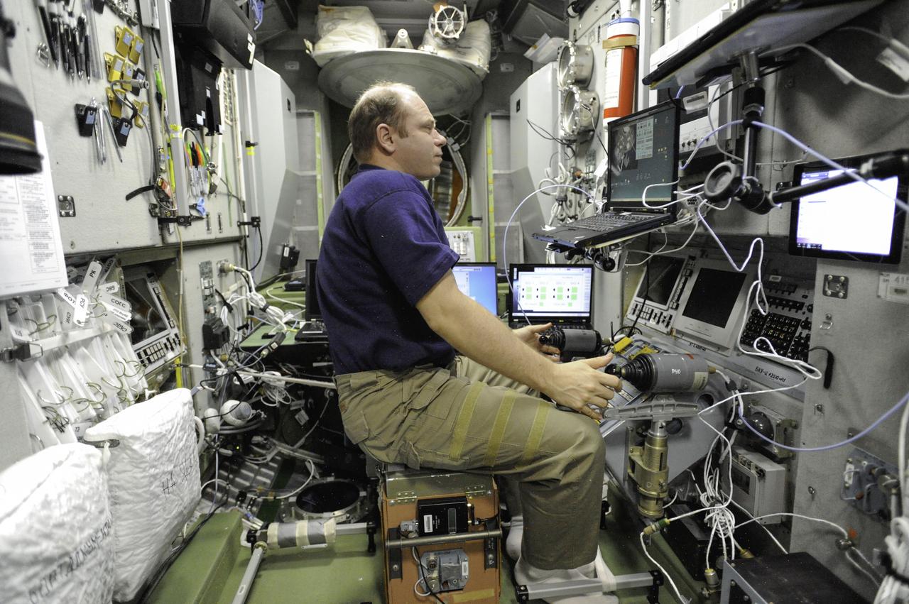 ISS038-E-006656 (22 Nov. 2013) --- Russian cosmonaut Oleg Kotov, Expedition 38 commander, practices manual docking techniques with the TORU, or telerobotically operated rendezvous system, in the Zvezda Service Module of the International Space Station in preparation for the docking of the Progress 53 spacecraft. Kotov, using the Simvol-TS screen and hand controllers, could manually dock the Progress to the station in the event of a failure of the Kurs automated docking system. The Progress 53 craft is scheduled to complete its automated docking to the aft port of Zvezda at 5:28 p.m. (EST) on Nov. 29.