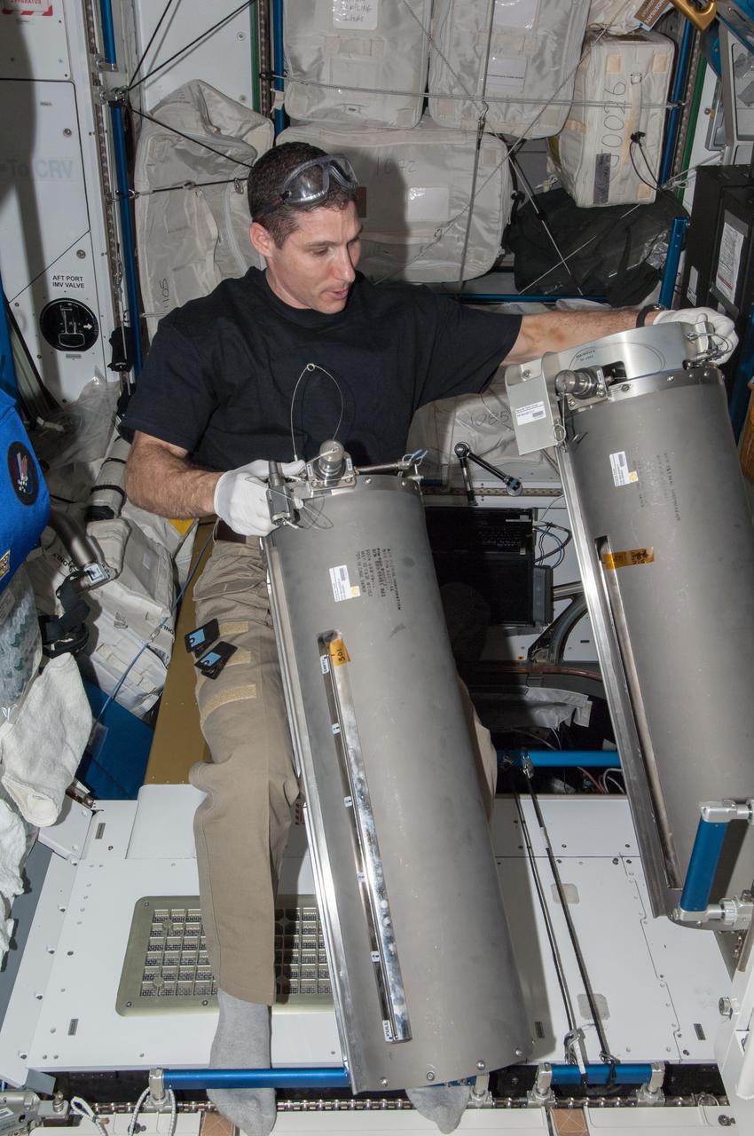 ISS038-E-008287 (24 Nov. 2013) --- NASA astronaut Michael Hopkins, Expedition 38 flight engineer, works with tanks from the Advanced Recycle Filter Tank Assembly (ARFTA) in the Tranquility node of the International Space Station.