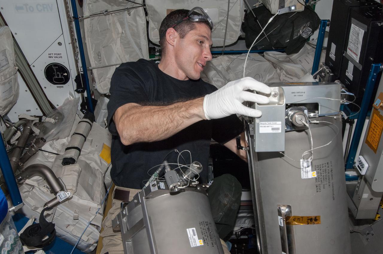 ISS038-E-008289 (24 Nov. 2013) --- NASA astronaut Michael Hopkins, Expedition 38 flight engineer, works with tanks from the Advanced Recycle Filter Tank Assembly (ARFTA) in the Tranquility node of the International Space Station.