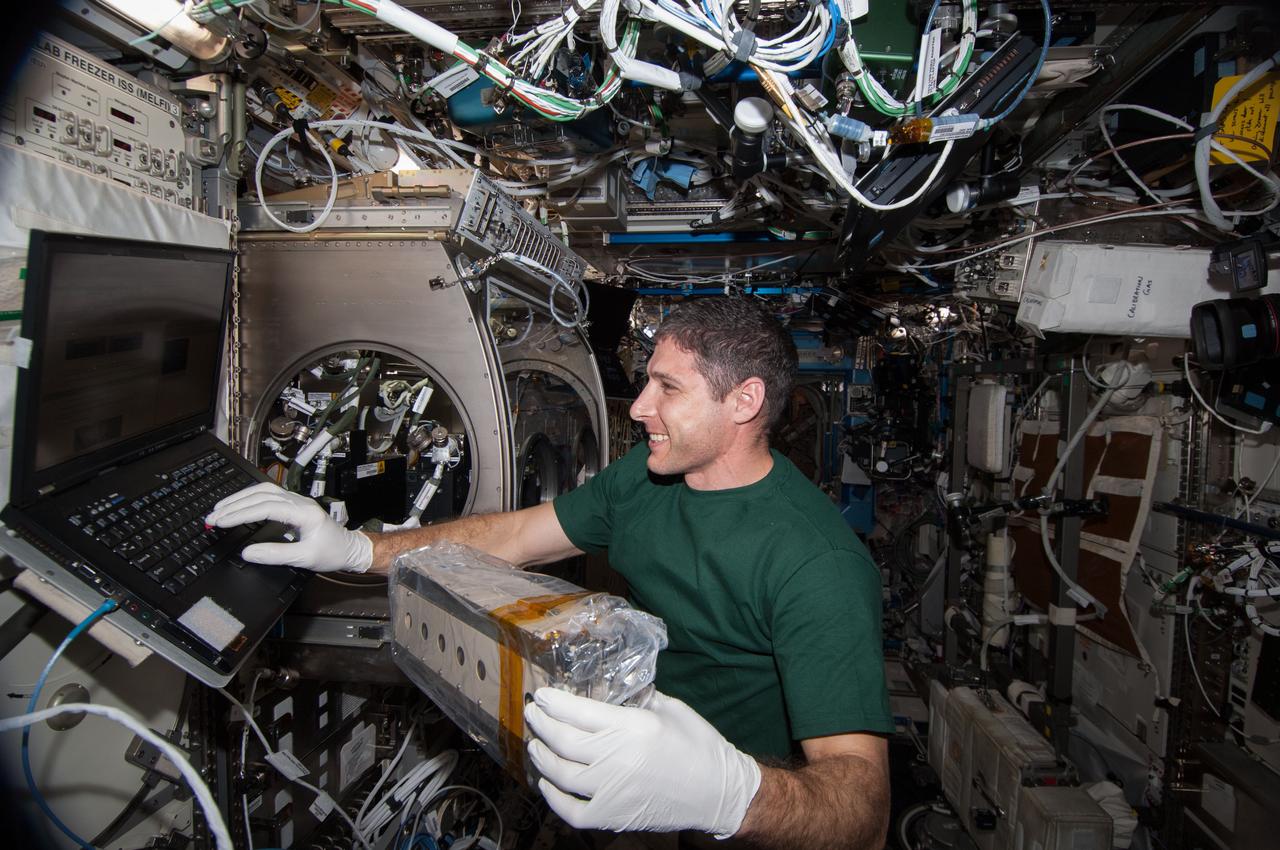 ISS038-E-009255 (26 Nov. 2013) --- In the International Space Station?s Destiny laboratory, NASA astronaut Michael Hopkins, Expedition 38 flight engineer, prepares to install and activate the Selectable Optics Diagnostic Instrument (SODI) cell array two in the Microgravity Science Glovebox (MSG) for the Selectable Optics Diagnostic Instrument-Diffusion Coefficient in Mixtures 2 (SODI-DCMIX 2) experiment. SODI-DCMIX 2 is supporting research to determine diffusion coefficients in different petroleum field samples and refine petroleum reservoir models to help lead to more efficient extraction of oil resources.