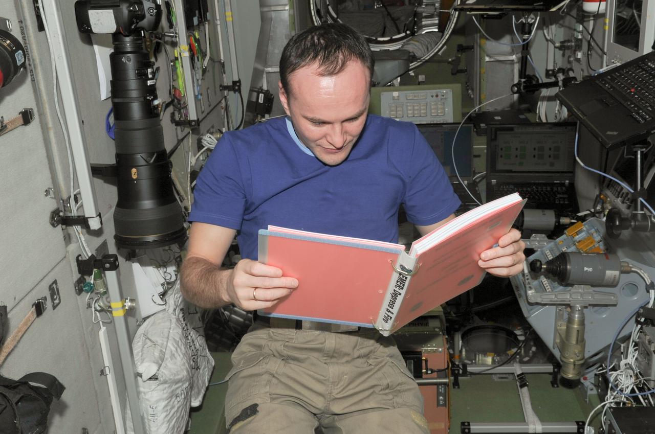 ISS038-E-011708 (4 Dec. 2013) --- In the International Space Station?s Zvezda Service Module, Russian cosmonaut Sergey Ryazanskiy, Expedition 38 flight engineer, reads a procedures checklist during an emergency simulation drill with participation from flight controllers on the ground. During the exercise, the crew practiced emergency communication and procedures in response to a predetermined scenario such as pressure leak.