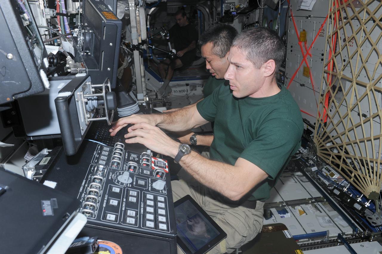 ISS038-E-011710 (4 Dec. 2013) --- In the International Space Station’s Destiny laboratory, NASA astronaut Michael Hopkins (foreground) and Japan Aerospace Exploration Agency astronaut Koichi Wakata, both Expedition 38 flight engineers, participate in an emergency simulation drill with participation from flight controllers on the ground. During the exercise, the crew practiced emergency communication and procedures in response to a predetermined scenario such as pressure leak.