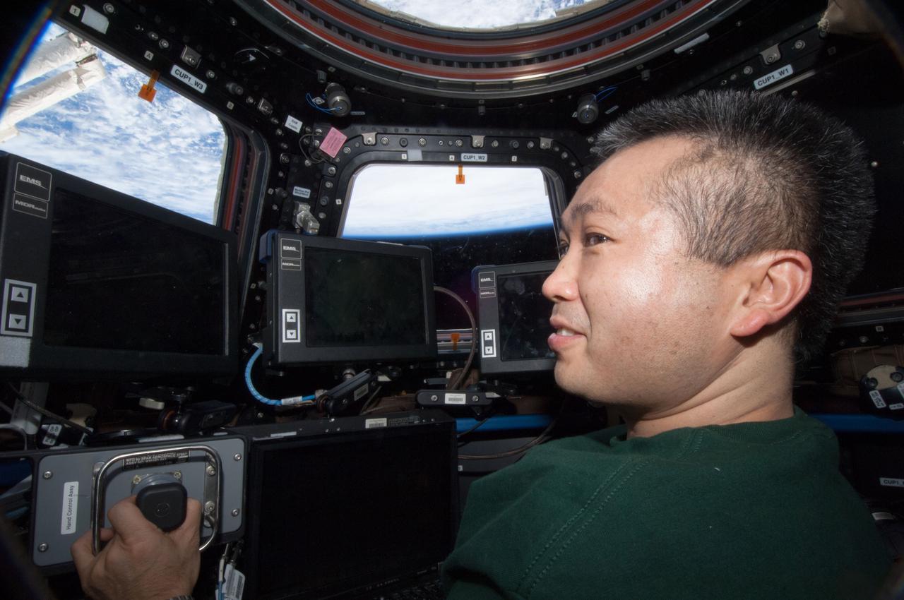 ISS038-E-011800 (4 Dec. 2013) --- Japan Aerospace Exploration Agency astronaut Koichi Wakata, Expedition 38 flight engineer, works the controls at the robotic workstation in the Cupola of the International Space Station.
