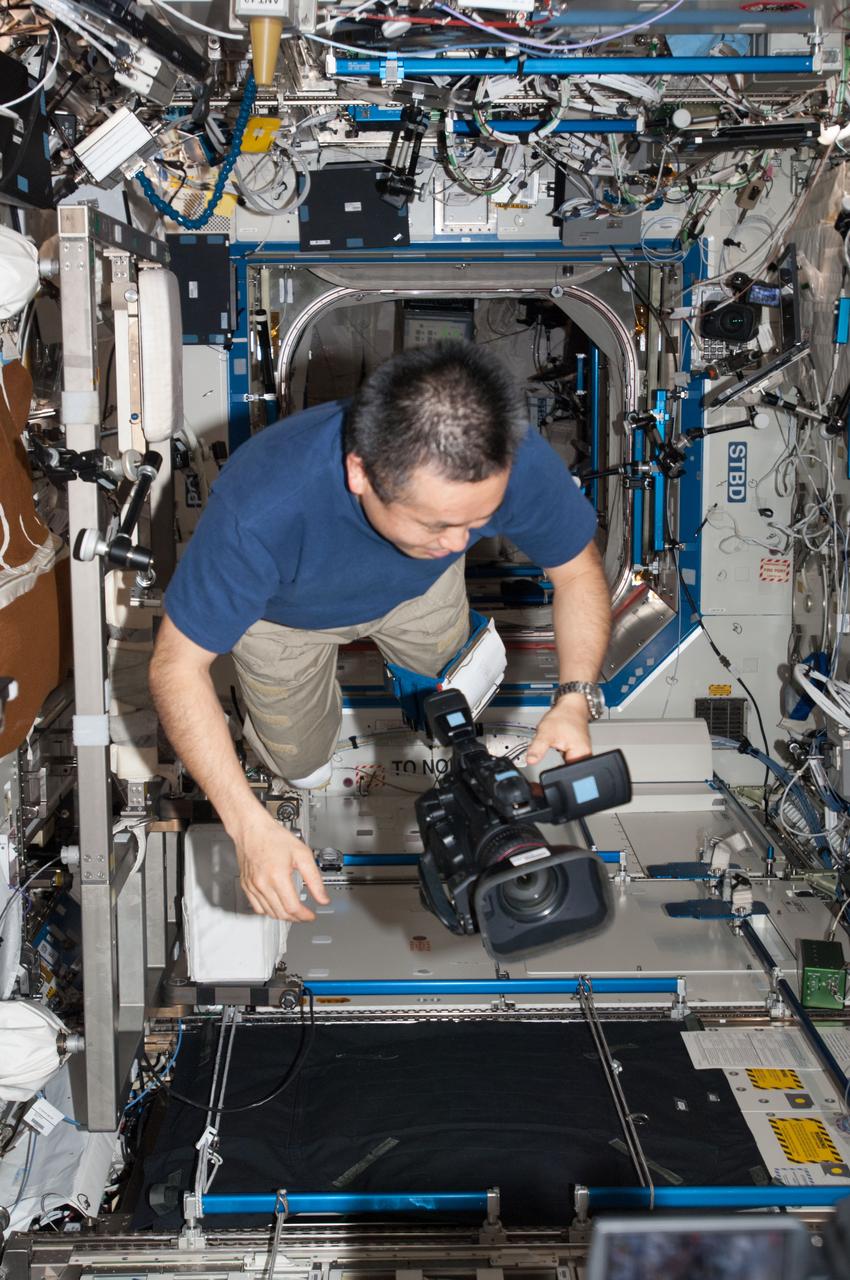 ISS038-E-015225 (11 Dec. 2013) --- Japan Aerospace Exploration Agency astronaut Koichi Wakata, Expedition 38 flight engineer, floats freely while holding a video camera in the Destiny laboratory of the International Space Station.