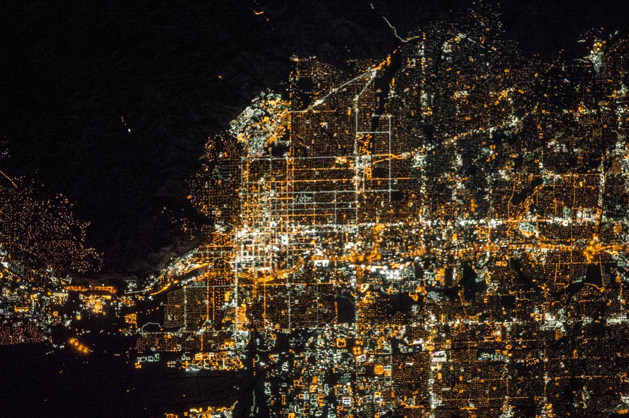ISS038-E-016506 (12 Dec. 2013) --- A nighttime view of Salt Lake City, Utah is featured in this image photographed by an Expedition 38 crew member on the International Space Station. The Salt Lake City metropolitan area is located along the western front of the Wasatch Range in northern Utah. Viewed at night from the vantage point of the space station, the regular north-south and east-west layout of street grids typical of western U.S. cities is clearly visible. Known as "the crossroads of the West", the headquarters of The Church of Jesus Christ of Latter-day Saints (also known as the LDS Church and informally as the Mormon Church), and the state capital of Utah, Salt Lake City was founded in 1847 by Brigham Young together with other followers of the Mormon faith. The Salt Lake City metropolitan area today is included in the larger urban Wasatch Front region of Utah which includes over two million people (approximately 80 percent of the population of the state). Both the color of the city lights and their density provide clues to the character of the urban fabric -- yellow gold lights generally indicate major roadways such as Interstate Highway 15 that passes through the center of the metropolitan area (center, left to right), while bright white clusters of lights are associated with city centers, commercial, and industrial areas. In contrast, residential and suburban areas are recognizable due to diffuse and relatively dim lighting (center left). The Wasatch Range to the east is largely dark, as are several large urban parks and golf courses located within the illuminated urban areas.