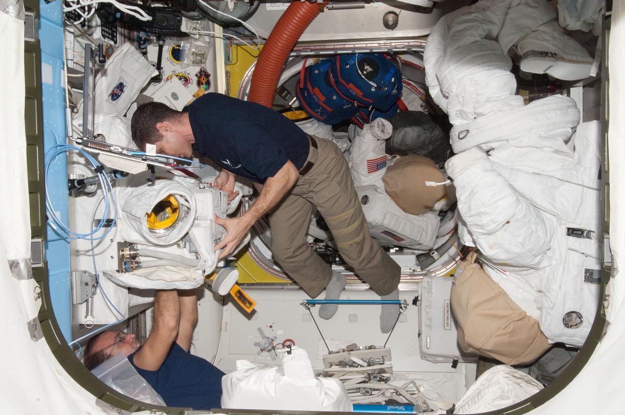 View of Mike Hopkins, Expedition 38 Flight Engineer (FE), during remove and replace (R&R) of Hard Upper Torso (HUT) of Extravehicular Mobility Unit (EMU), in the airlock (A/L) during preparation for EVA-24.  Photo was taken during Expedition 38.  Image was released by astronaut on Twitter.