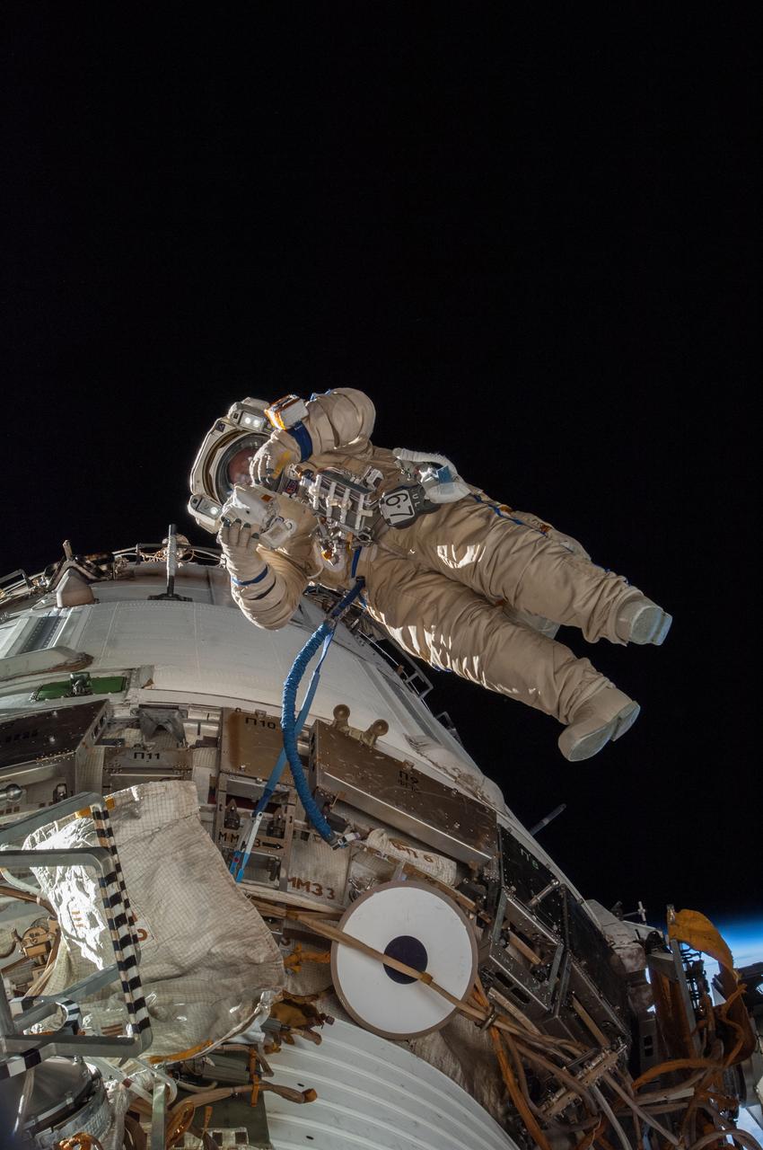 ISS038-E-022922 (27 Dec. 2013) --- Russian cosmonaut Sergey Ryazanskiy, Expedition 38 flight engineer, attired in a Russian Orlan spacesuit, participates in a session of extravehicular activity (EVA) in support of assembly and maintenance on the International Space Station. During the eight-hour, seven-minute spacewalk, Ryazanskiy and Russian cosmonaut Oleg Kotov (out of frame), commander, worked with two high-fidelity cameras, removed the Vsplesk experiment package and jettisoned it and replaced it with hardware for a more sophisticated earthquake-monitoring experiment, Seismoprognoz, which they attached to a Zvezda handrail.