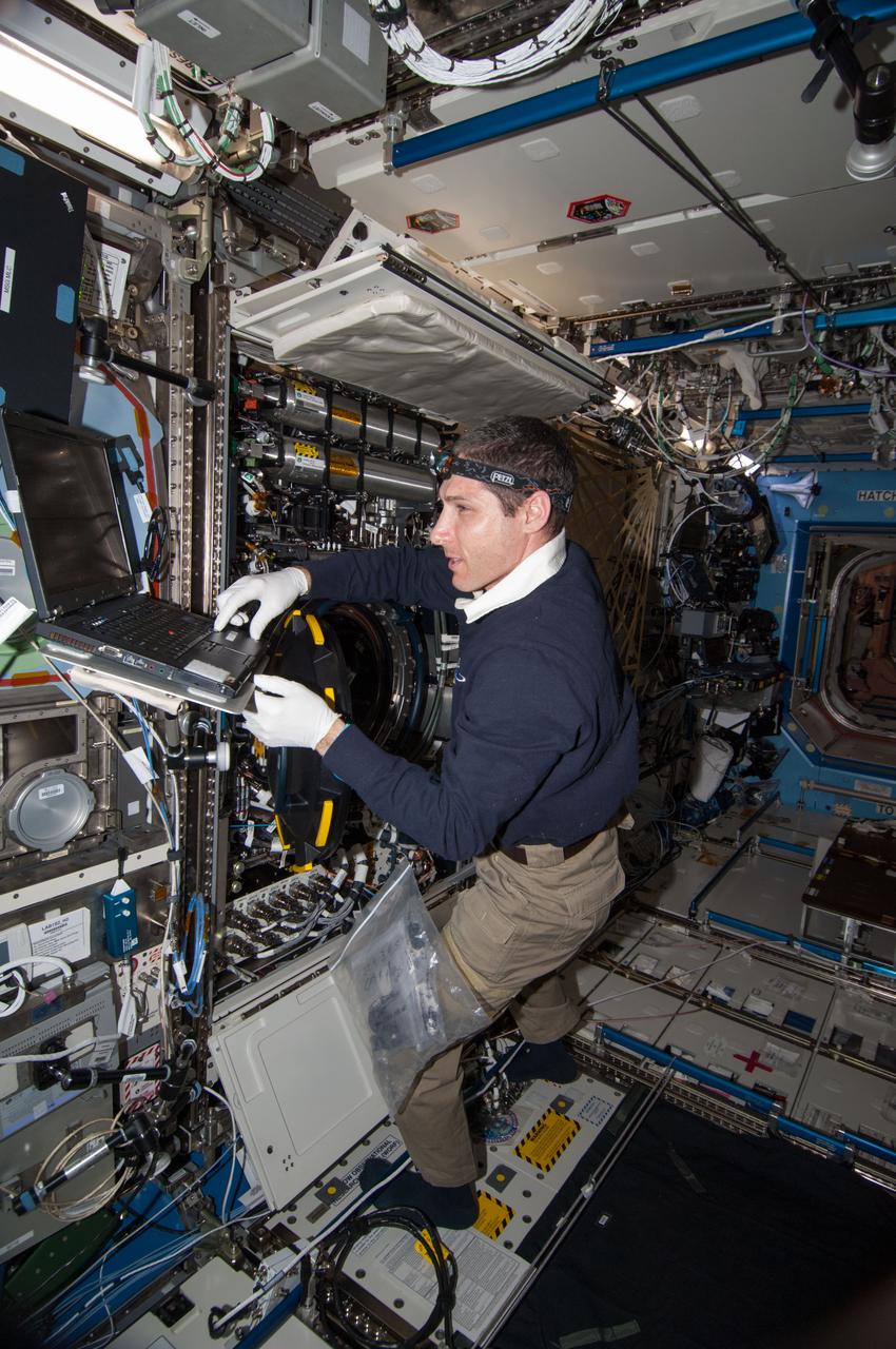 ISS038-E-024145 (30 Dec. 2013) --- NASA astronaut Mike Hopkins, Expedition 38 flight engineer, performs in-flight maintenance on combustion research hardware in the Destiny laboratory of the International Space Station. Hopkins replaced a Multi-user Droplet Combustion Apparatus (MDCA) fuel reservoir inside the Combustion Integrated Rack (CIR).
