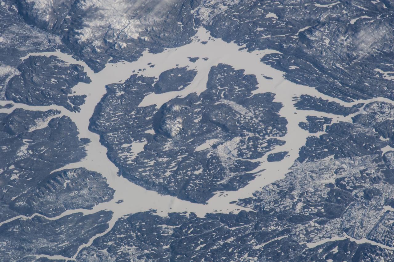 ISS038-E-025350 (2 Jan. 2014) --- One of the Expedition 38 crew members aboard the Earth-orbiting International Space Station recorded this image which features the Manicouagan Crater and reservoir located primarily in Manicouagan Regional County Municipality in the Cote-Nord region of Quebec, Canada. Scientists believe the crater was caused by the impact of a 5 kilometer (3 mile) diameter asteroid about 215.5 million years ago (Triassic Period). The crater is a multiple-ring structure about 100 kilometers (60 miles) across, with its 70 kilometer (40 mile) diameter inner ring as its most prominent feature; it contains a 70 kilometer (40 mile) diameter annular lake, the Manicouagan Reservoir, surrounding an inner island plateau, Rene-Levasseur Island. Because it is so unique and easily recognizable from the sky and space, the crater has been the subject of hundreds of images from astronauts for 45-plus years.