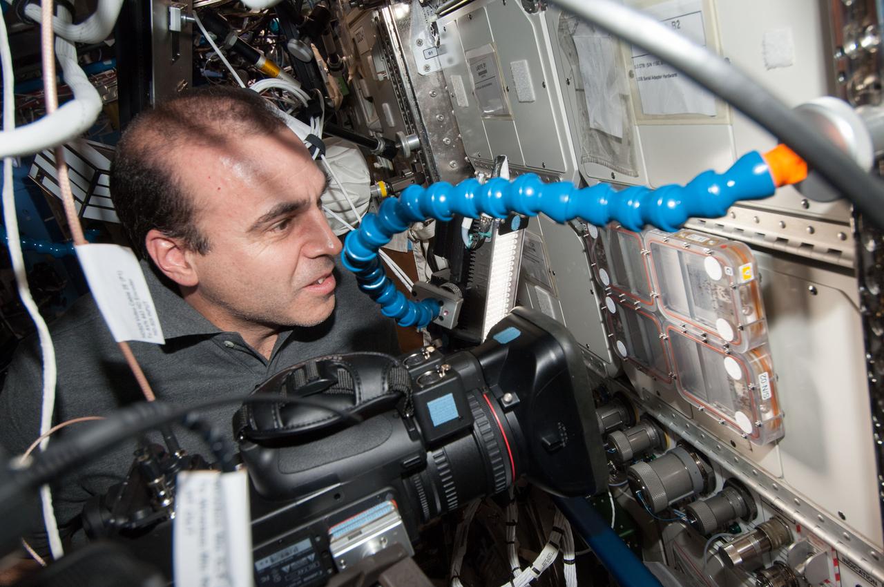 ISS038-E-029062 (12 Jan. 2014) --- In the International Space Station's Destiny laboratory, NASA astronaut Rick Mastracchio, Expedition 38 flight engineer, uses a video camera to photograph the Ant Forage Habitat Facility which will study ant behavior and colonization in microgravity.