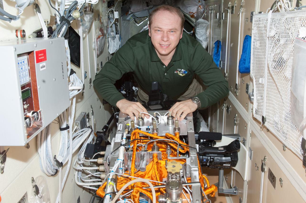 ISS038-E-029764 (13 Jan. 2014) --- Russian cosmonaut Oleg Kotov, Expedition 38 commander, sets up the Particle Cooler/Generator Module for the Kaplya-2 experiment in the Rassvet Mini-Research Module 1 (MRM1) of the International Space Station.