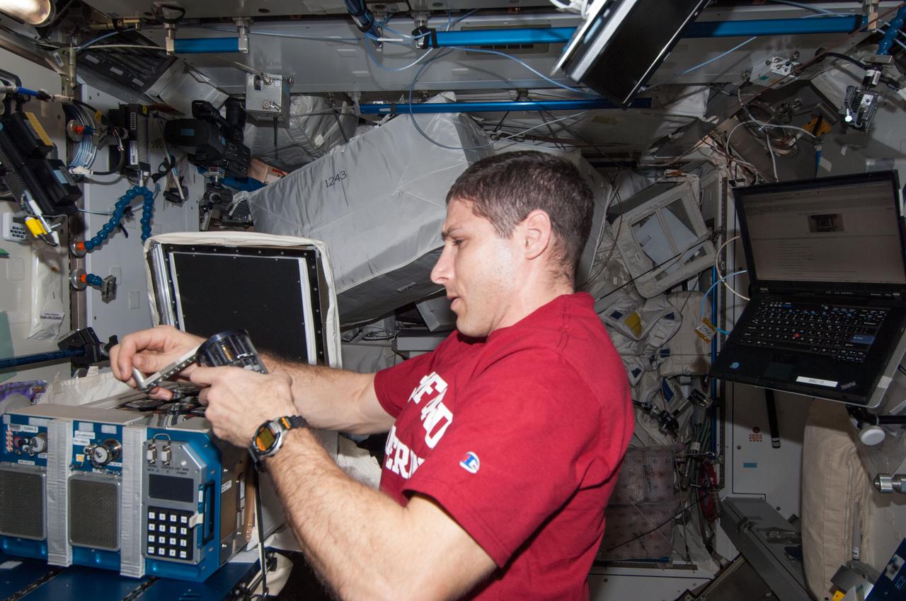ISS038-E-031400 (14 Jan. 2014) --- NASA astronaut Mike Hopkins, Expedition 38 flight engineer, accesses the Commercial Generic Bioprocessing Apparatus-2 (CGBA-2) while working with the Vaccine-21 Group Activation Pack (GAP) experiment in the Harmony node of the International Space Station. This experiment also referred to as Antibiotic Effectiveness in Space-1 (AES-1) tests the hypothesis that antibiotics used to treat bacterial grown in space will exhibit reduced efficacy and will be associated with specific changes in bacterial gene expression that correlate with cell survival.