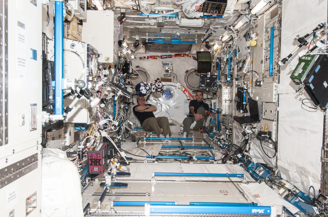 ISS038-E-031405 (15 Jan. 2014) --- In the International Space Station's Kibo laboratory, Russian cosmonaut Oleg Kotov (left), Expedition 38 commander; and NASA astronaut Rick Mastracchio, flight engineer, conduct a session with a pair of bowling-ball-sized free-flying satellites known as Synchronized Position Hold, Engage, Reorient, Experimental Satellites, or SPHERES. The experiment uses student written algorithms that operate the small satellites to demonstrate critical mission tasks such as formation flying and vehicle dockings.