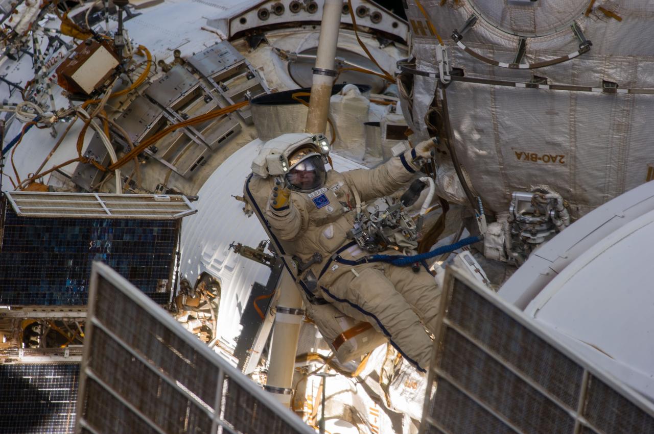ISS038-E-036319 (27 Jan. 2014) --- Russian cosmonauts Oleg Kotov, Expedition 38 commander, and Sergey Ryazanskiy (out of frame), flight engineer, attired in Russian Orlan spacesuits, participate in a session of extravehicular activity (EVA) in support of assembly and maintenance on the International Space Station. During the six-hour, eight-minute spacewalk, Kotov and Ryazanskiy completed the installation of a pair of high fidelity cameras that experienced connectivity issues during the Dec. 27 spacewalk, and retrieved scientific gear outside the station's Russian segment.