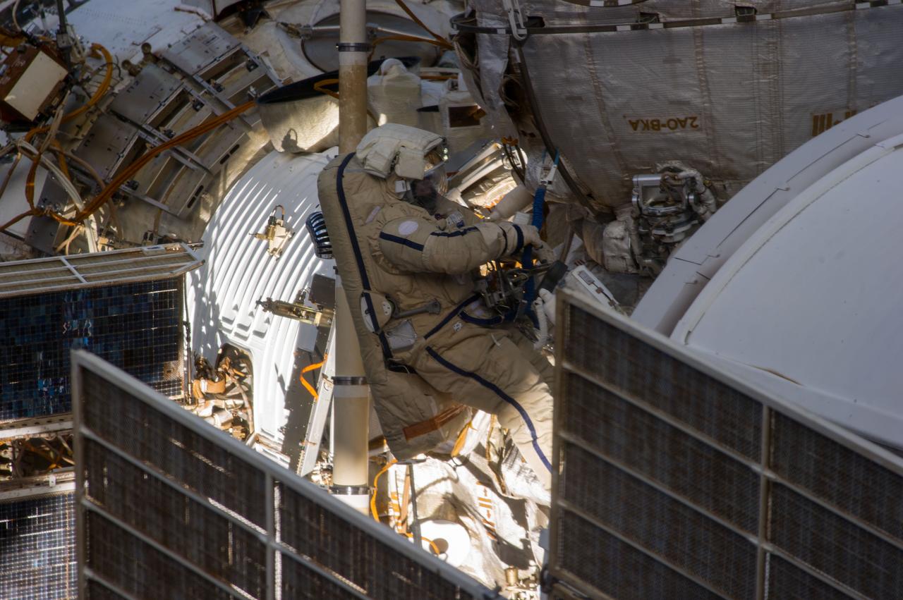 ISS038-E-036326 (27 Jan. 2014) --- Russian cosmonauts Oleg Kotov, Expedition 38 commander, and Sergey Ryazanskiy (out of frame), flight engineer, attired in Russian Orlan spacesuits, participate in a session of extravehicular activity (EVA) in support of assembly and maintenance on the International Space Station. During the six-hour, eight-minute spacewalk, Kotov and Ryazanskiy completed the installation of a pair of high fidelity cameras that experienced connectivity issues during the Dec. 27 spacewalk, and retrieved scientific gear outside the station's Russian segment.