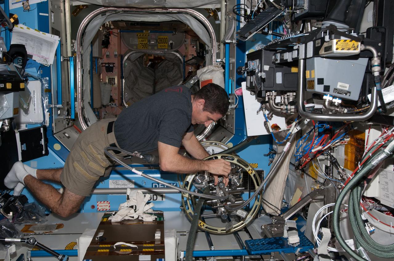 ISS038-E-040140 (31 Jan. 2014) --- NASA astronaut Mike Hopkins, Expedition 38 flight engineer, uses the Fluid Servicing System (FSS) to refill Internal Thermal Control System (ITCS) loops with fresh coolant in the Destiny laboratory of the International Space Station.