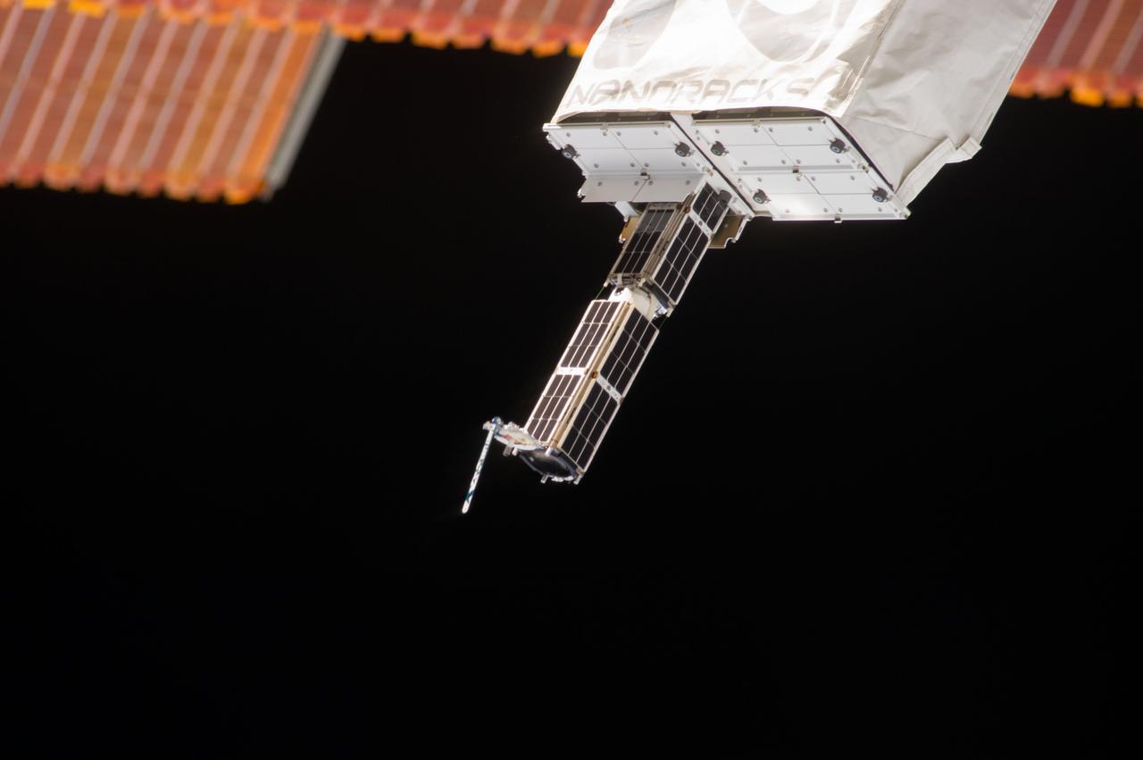 ISS038-E-044887 (11 Feb. 2014) --- The Small Satellite Orbital Deployer (SSOD), in the grasp of the Kibo laboratory robotic arm, is photographed by an Expedition 38 crew member on the International Space Station as it deploys a set of NanoRacks CubeSats. The CubeSats program contains a variety of experiments such as Earth observations and advanced electronics testing.