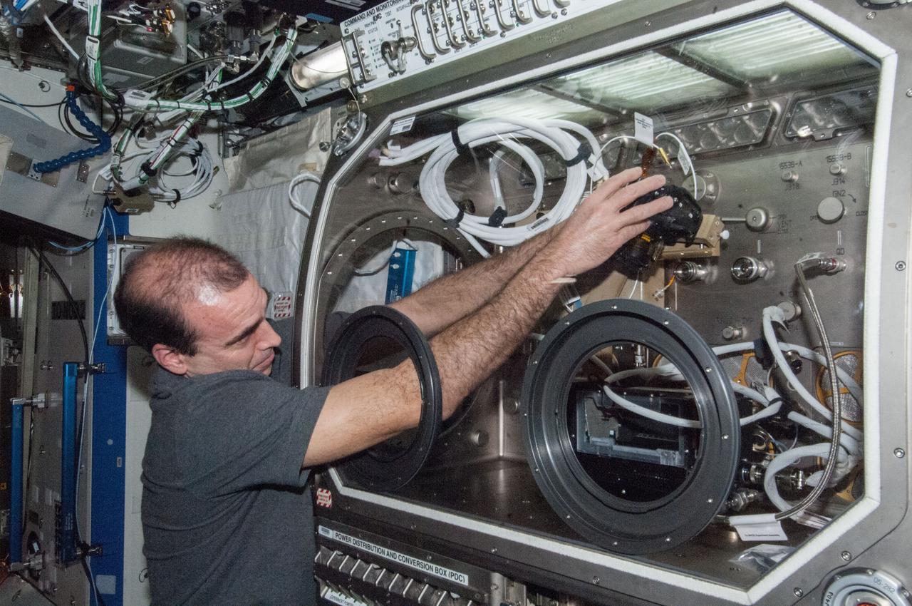 ISS038-E-046387 (12 Feb. 2014) --- NASA astronaut Rick Mastracchio, Expedition 38 flight engineer, sets up the Microgravity Science Glovebox (MSG) for the Burning and Suppression of Solids (BASS-II) experiment in the Destiny laboratory of the International Space Station. BASS-II explores how different substances burn in microgravity with benefits for combustion on Earth and fire safety in space.