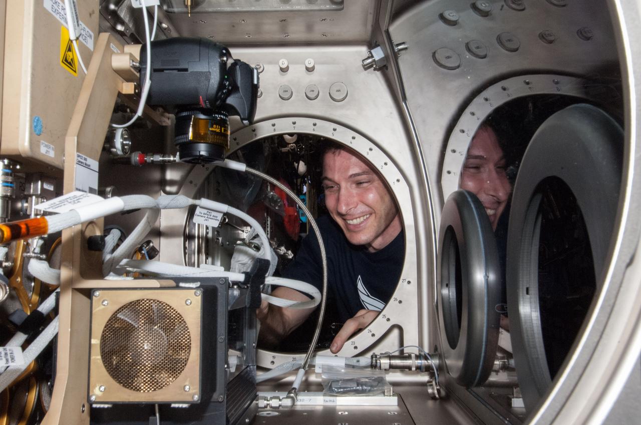 ISS038-E-046394 (12 Feb. 2014) --- NASA astronaut Mike Hopkins, Expedition 38 flight engineer, sets up the Microgravity Science Glovebox (MSG) for the Burning and Suppression of Solids (BASS-II) experiment in the Destiny laboratory of the International Space Station. BASS-II explores how different substances burn in microgravity with benefits for combustion on Earth and fire safety in space.