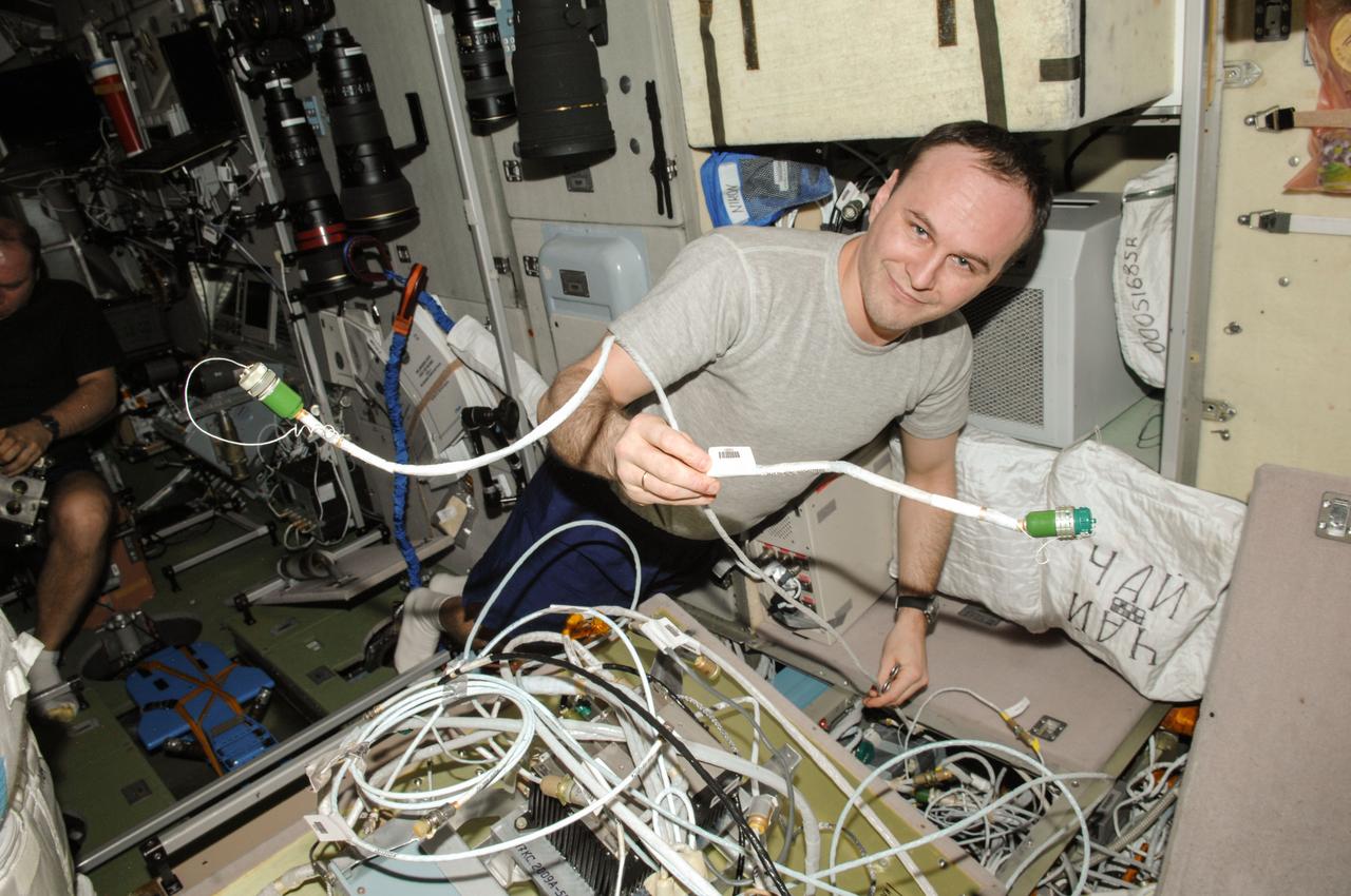 ISS038-E-051648 (20 Feb. 2014) --- Russian cosmonaut Sergey Ryazanskiy, Expedition 38 flight engineer, works with cables in the Zvezda Service Module of the International Space Station.