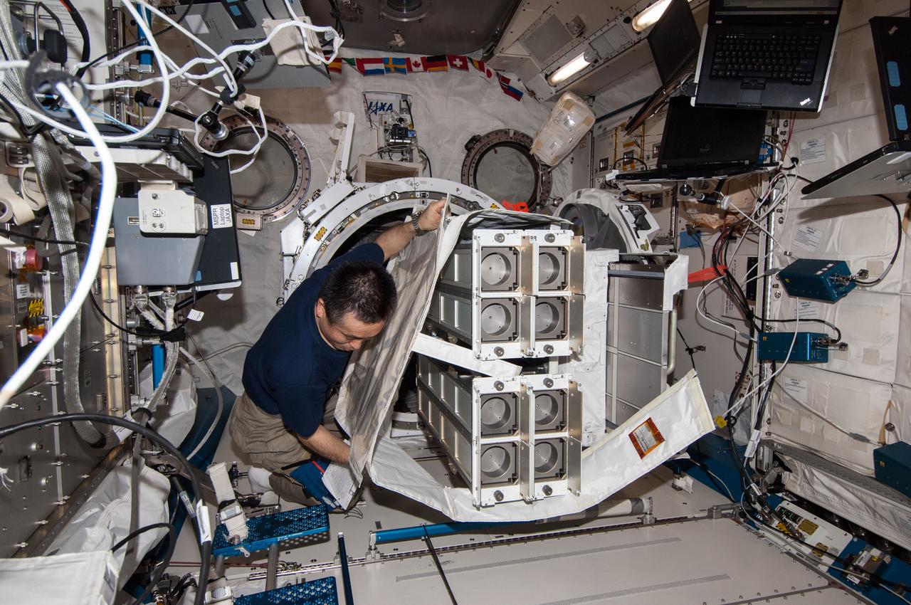 ISS038-E-053264 (19 Feb. 2014) --- In the International Space Station's Kibo laboratory, Japan Aerospace Exploration Agency astronaut Koichi Wakata, Expedition 38 flight engineer, prepares a second batch of NanoRacks CubeSats for deployment.
