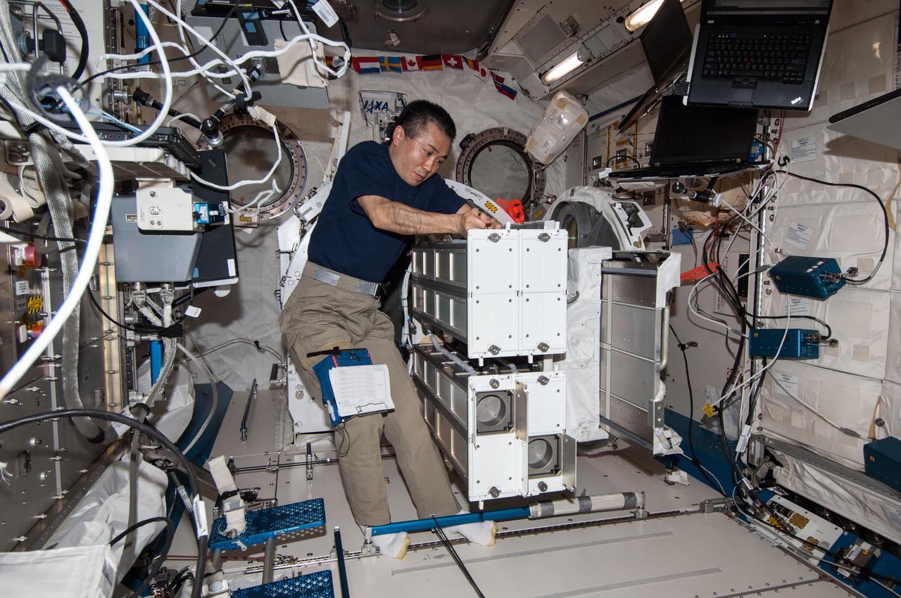 ISS038-E-053269 (19 Feb. 2014) --- In the International Space Station's Kibo laboratory, Japan Aerospace Exploration Agency astronaut Koichi Wakata, Expedition 38 flight engineer, prepares a second batch of NanoRacks CubeSats for deployment.