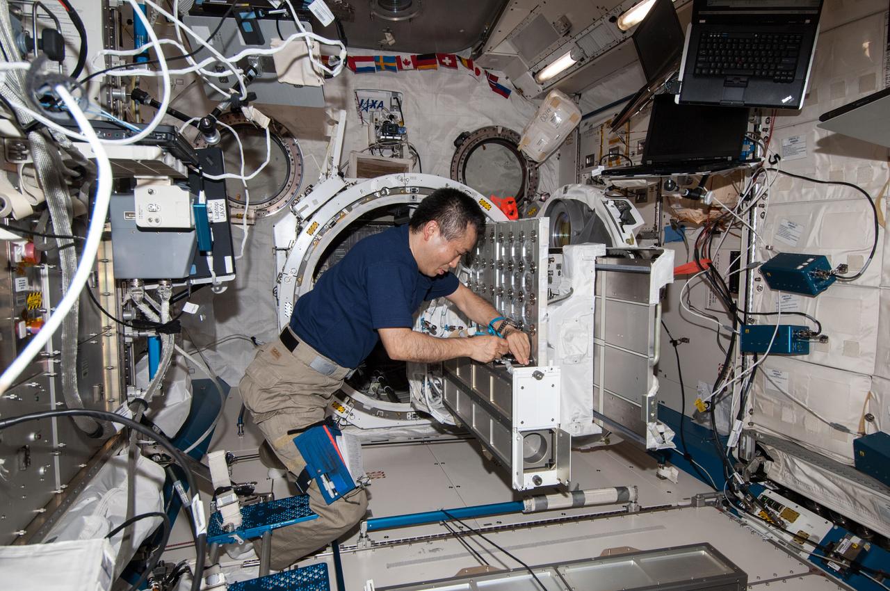 ISS038-E-053280 (19 Feb. 2014) --- In the International Space Station's Kibo laboratory, Japan Aerospace Exploration Agency astronaut Koichi Wakata, Expedition 38 flight engineer, prepares a second batch of NanoRacks CubeSats for deployment.
