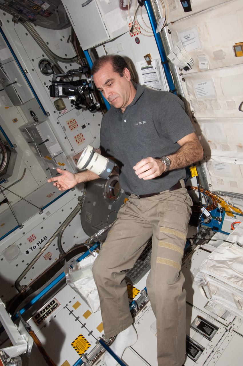 ISS038-E-053780 (18 Feb. 2014) --- NASA astronaut Rick Mastracchio, Expedition 38 flight engineer, uses a Microbial Air Sampler to collect air samples in the Unity node of the International Space Station. These air samples will be incubated for five days and tested for signs of microbial contamination.