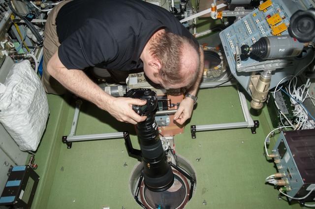 NASA image: Kotov holds 400mm camera lens in the SM