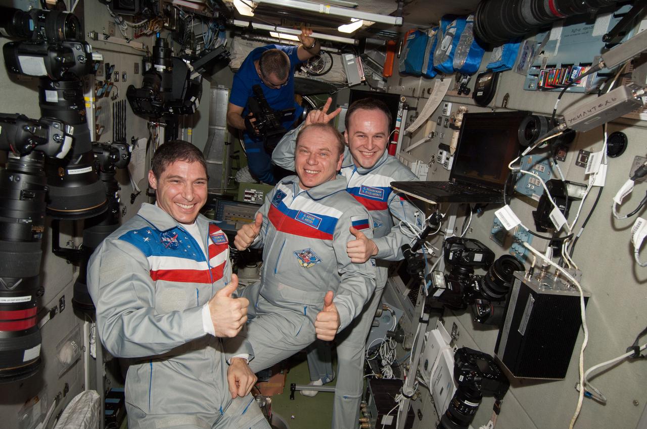 ISS038-E-068952 (10 March 2014) --- In the Zvezda service module of the International Space Station, three members of the Expedition 38 crew give a simultaneous thumbs up signal, which is perhaps a way of saying, "Our work is done here for now and we're ready to return home."  From left to right are Expedition 38 Flight Engineer Mike Hopkins of NASA, Commander Oleg Kotov of Russia's Federal Space Agency (Roscosmos) and Flight Engineer Sergey Ryazanskiy of Roscosmos.  Expedition 38/39 Flight Engineer Mikhail Tyurin, representing Roscosmos, prepares to record final activities among the three who are departing and the three (out of frame) who are remaining onboard to finish out their stay on the orbital outpost, as part of the Expedition 39 crew.