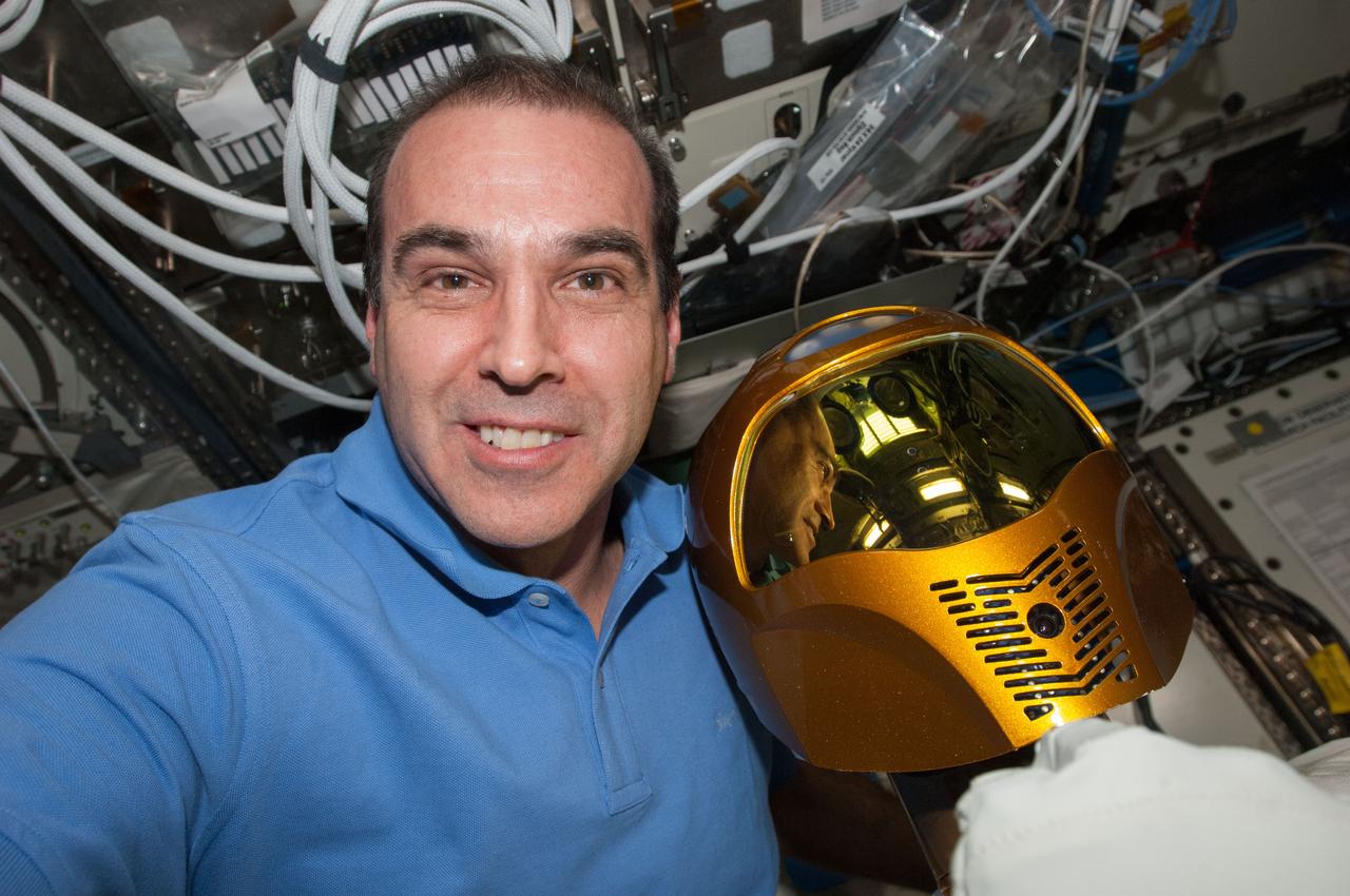 ISS039-E-003797 (15 March 2014) --- Expedition 39 flight engineer Rick Mastracchio poses for a self-portrait with Robonaut 2 in the  U.S. Laboratory  (Destiny) during a televised public event.   (Note: The event was shown live on March 14 in U.S. time zones).