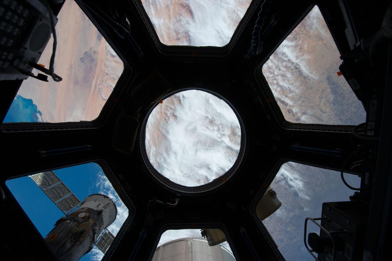 Earth observation taken through Cupola windows by the Expedition 39 crew. Portions of the ISS are in view. Image was released by astronaut on Twitter.